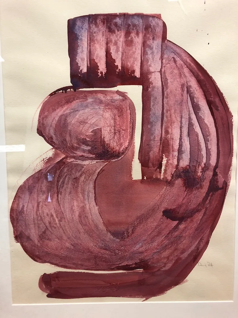 The curling maroon form photographed square to the sheet.