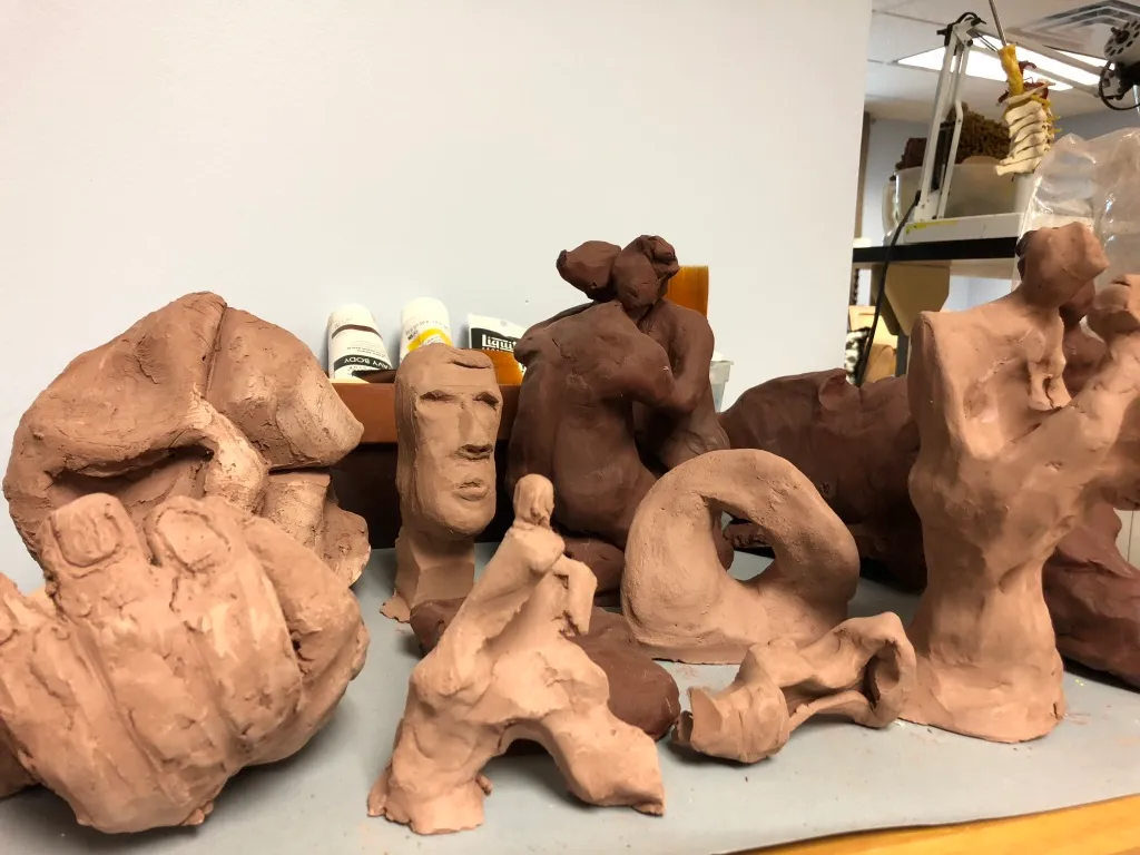 The studio group seen from the left, the shelves of the workroom behind.